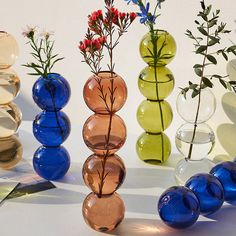 several different colored vases with flowers in them