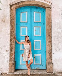 a woman standing in front of a blue door with the caption instagramn