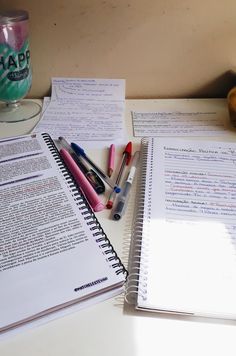 notebooks and pens are sitting on a desk