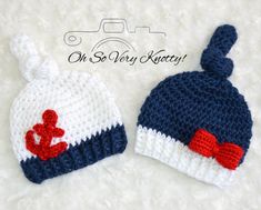 two crocheted hats with red bows and an anchor on the front one is blue and white