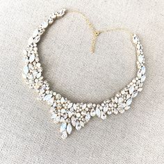 This Swarovski Rhinestone Statement Wedding Necklace features a combination of genuine Swarovski pearls and rhinestones with a high impact sparkle that will surely wow! Each stone is hand placed onto the design for a truly one of a kind, handmade statement bridal necklace. The details in this piece are beyond gorgeous. Choose silver or gold, and Ivory/Cream Pearls or White pearls at checkout to make this piece your own! You can even choose any of our 12 rhinestone colors ( or pick two! ) to trul Elegant Bridal Necklace With Stones For Anniversary, Elegant Bridal Necklace With Stones, Elegant Bridal Necklace With Stones For Wedding, Dazzling Necklaces With Stones For Wedding, Dazzling Wedding Necklaces With Stones, Elegant Jeweled Necklaces For Celebration, Cubic Zirconia Jeweled Necklaces For Wedding, Dazzling Jeweled Necklace For Weddings, Dazzling Jeweled Wedding Necklace