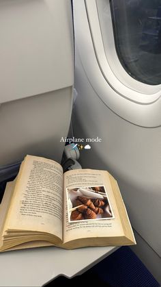 an open book sitting on top of an airplane seat