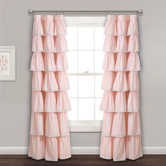 the pink ruffled curtains are hanging in front of a window