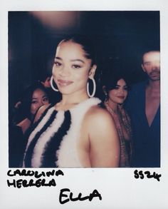 a woman with large hoop earrings standing next to other people