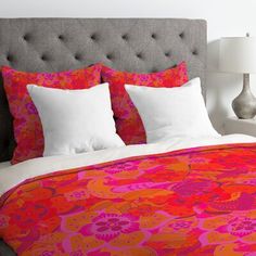 an orange and pink bed with white pillows