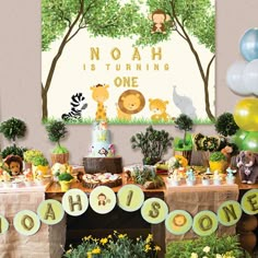 a table topped with lots of cake and balloons next to a sign that says noah is turning one