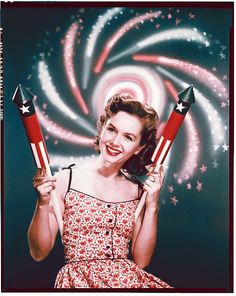 a woman holding two red and white rockets