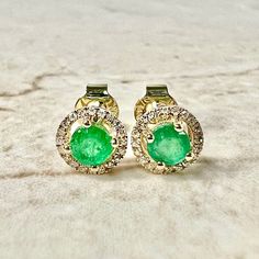 Beautiful 14 karat yellow gold emerald and diamond stud earrings. They feature two natural 4 mm round emeralds the birthstone for May! The gemstones weigh approximately 1/2 carat. They are haloed by 40 diamonds weighing approximately 0.10 carat. G-H SI. Closure: Push Backs. Width: 7.04 mm. Birthstone: May/April. Condition: Brand New. - 14 day return policy, no questions asked. - Free insured shipping in the US. - International shipping available. Note: All items have been appraised and inspected Halo Stud Earrings, Halo Earrings Studs, May Birthstone, Diamond Stud Earrings, Diamond Stud, Diamond Halo, 2 Carat, Emerald Diamond, Diamond Earrings Studs