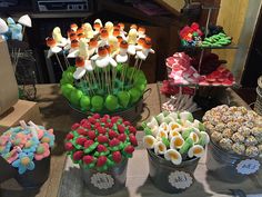 an assortment of desserts are displayed in buckets on a table at a party