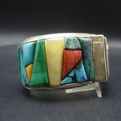 "VINTAGE ANDREW ALVAREZ BRACELET DESCRIPTION: This outstanding cuff is from celebrated artisan Andrew Alvarez. Extremely heavy gauge sterling silver is adorned with cobblestone inlay of turquoise, malachite, spiny oyster shell, and mother of pearl. This exquisite bracelet will be a cherished addition to your collection of fine vintage Southwest and Native American jewelry. MEASUREMENTS: Interior of the cuff measures 5 1/2\" with an additional 1 1/8\" non-adjustable gap. Total circumference: 6 5/ Vintage Cuff Bracelet With Natural Stones, Vintage Bangle Cuff Bracelet With Natural Stones, Vintage Natural Stones Cuff Bracelet, Vintage Natural Stones Cuff Bangle, Vintage Adjustable Gemstone Cuff Bracelet, Multicolor Natural Stones Cuff Bangle, Adjustable Vintage Gemstone Cuff Bracelet, Vintage Bangle Bracelet With Natural Stones, Vintage Cuff Bracelet With Natural Stones Gift