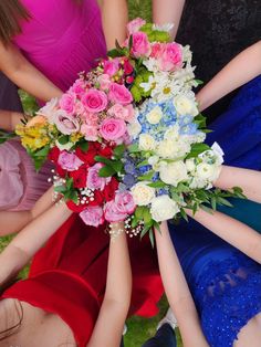 a group of women in dresses holding hands together