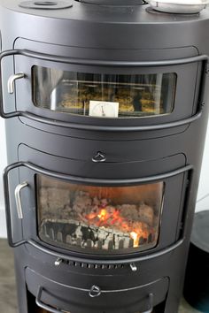 a black stove top oven sitting on top of a wooden floor next to a white wall