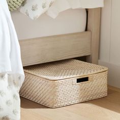 a basket sitting on the floor next to a bed