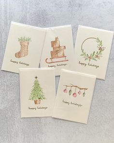 four christmas cards with watercolor designs on them