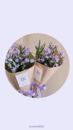 two purple flowers are wrapped in brown paper and tied with a purple ribbon around them