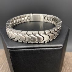 Heavy, stainless steel “Serpentine” style chain bracelet in watch band styling. 8 1/2” in length 1/2” in width stamped “stainless steel” insert, push-button, safety clasp Formal Gunmetal Stainless Steel Jewelry, Modern Gunmetal Chain Bracelet In Stainless Steel, Modern Gunmetal Jewelry With Bracelet Strap, Gunmetal Stainless Steel Chain Bracelet, Elegant Stainless Steel Chain Bracelet In Gunmetal, Adjustable Stainless Steel Chain Bracelet, Modern Adjustable Gunmetal Chain Bracelet, Modern Gunmetal Stainless Steel Chain Bracelet, Modern Stainless Steel Jewelry With Stainless Clasp