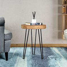 a living room with a chair, table and books on the shelf next to it