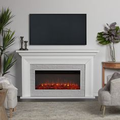 a living room with a fire place and two chairs in front of the fireplace that is lit