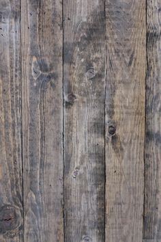 an old wooden wall with peeling paint on the top and wood grains all around it