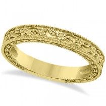 a gold wedding band with intricate designs on it