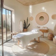 a spa room with white towels on the bed and plants in baskets around the bathtub