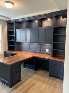 an empty office with built - in cabinets and desks on the wall, along with hard wood flooring