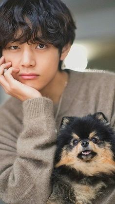 a man holding a small dog in his lap and looking at the camera with an intense look on his face