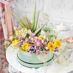 an arrangement of flowers and candles on a table