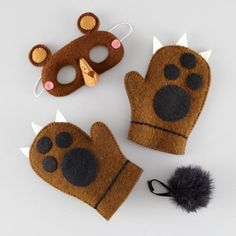 three felt animal mittens and a mask on a white surface