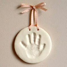 a white ceramic ornament with a handprint on it