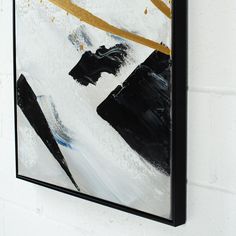 a black and white painting hanging on the wall