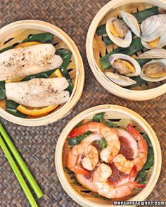 three bowls filled with food next to chopsticks on top of a woven mat