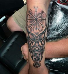 a man with a tattoo on his arm has a goat head and cross in the middle