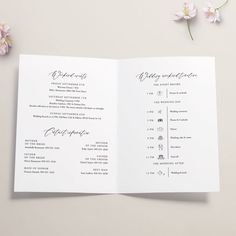 an open wedding program with pink flowers on the side and white paper in the middle