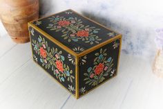 a decorative box sitting on top of a wooden table next to a potted plant