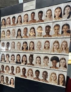 a woman standing in front of a display of women's faces