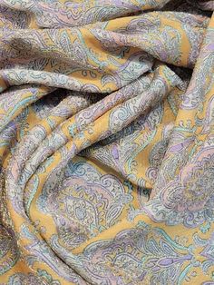 the fabric is yellow and blue with paisley designs on it's sides, as well as