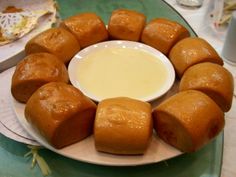 a white plate topped with rolls next to a bowl of dip