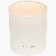 a candle that is sitting in a white glass container with the words, sarah ellison on it