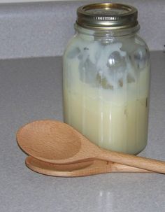 a wooden spoon sitting on top of a counter next to a jar filled with liquid