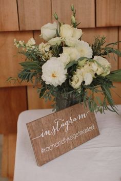 a wooden sign that says instagram on it next to a vase filled with flowers