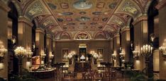 an ornately decorated lobby with chandeliers and tables in front of the ceiling