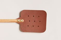 a wooden spatula with holes in it