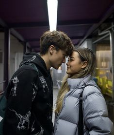 a young man and woman standing next to each other