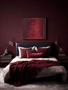 a bed with red pillows and blankets in a dark colored room, along with two lamps on either side of the bed