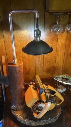 a lamp that is sitting on top of a table with other items around it and some wine glasses in the background