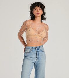 Give off flirty vibes in this trendy sheer mesh embellished crop top perf for parties! It features faux pearl and rhinestone embellishments in chic flower designs and all-over rhinestones for added sparkle. The top is shaped with a crew neckline, long fitted sleeves, and a fitted cropped hem. Style over a basic bralette or mini dress!Fit & FeaturesSheer mesh fabricFaux pearl and rhinestone embellishments, flower designsAll-over rhinestonesCrew necklineLong fitted sleevesFitted cropped hemRun Glamorous Mesh Top For Spring, Spring Mesh Top With Mesh Sleeves For Night Out, Sheer Mesh Crop Top For Party, Embellished Stretch Mesh Top For Summer, Sheer Sleeve Crop Top For Summer Night Out, Sheer Sleeves Crop Top For Night Out In Summer, Summer Night Out Crop Top With Sheer Sleeves, Trendy Sheer Fitted Crop Top, Summer Fitted Crop Top With Sheer Sleeves