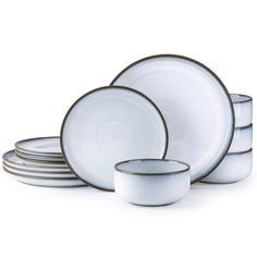 a set of white dishes with gold rims