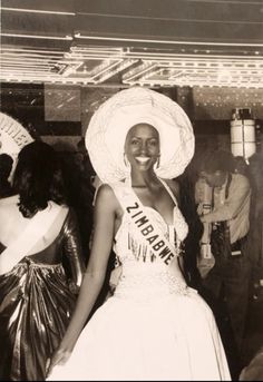 a black and white photo of a woman wearing a sash