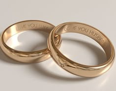 two gold wedding rings with i love you husband written on them